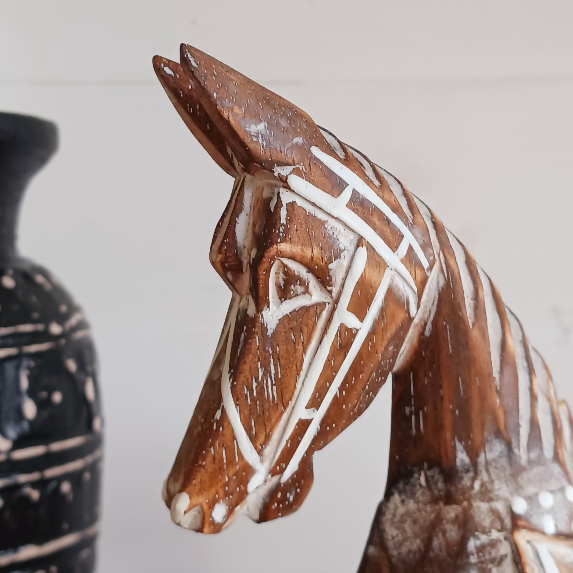 Handcrafted from albasia wood, this antique horse features intricate carvings and a beautiful distressed finish, exuding a timeless charm that appeals to all. Ideal for adding a touch of vintage elegance to any space, this piece is versatile enough to complement various interior styles. Its compact size ensures it fits seamlessly on shelves, mantels, or as part of a centerpiece.