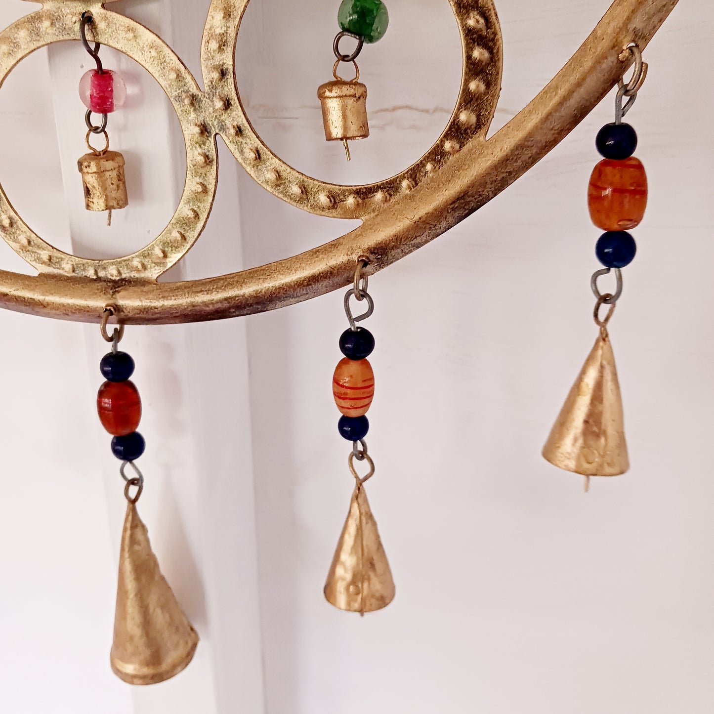 Enhance your living space with this beautiful large Buddha face 15 bell chimes.  This lovely brass decoration exudes serenity and spiritual charm. An intricate piece featuring a serene Buddha face surrounded by delicate circular accents and vibrant, colourful beads. With 15 brass bells, this chime creates a harmonious, soothing sound, making it ideal for both indoor and outdoor spaces.