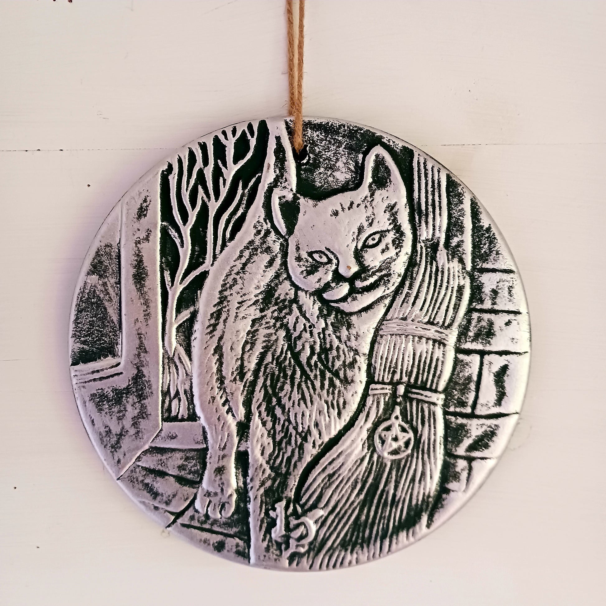 This stunning terracotta wall plaque has a silver-like finish with Lisa Parker's 'A Brush With Magic' artwork featuring a cat and witch's broom.