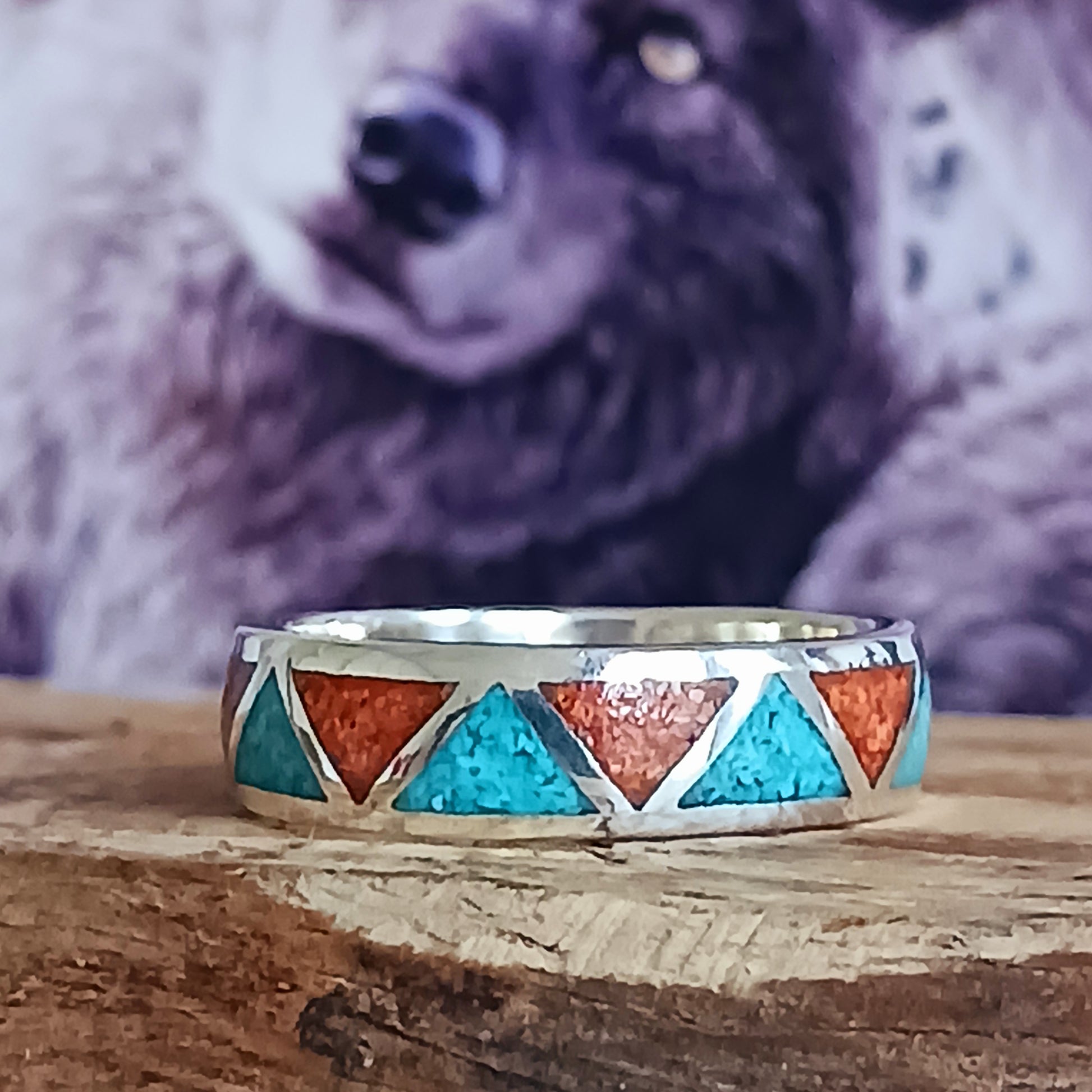 This beautiful inlaid Silver Turquoise Coral Navajo Ring offers a traditional, Native American pattern. Opposing triangles are fitted with hand crushed, gemstone chips. Set in Sterling Silver, this ring offers a smooth flat surface that will fit comfortably on your finger or thumb.  Perfect for his and her bands, this inlaid Silver Turquoise Coral Navajo Ring is a nice contrast for any occasion.