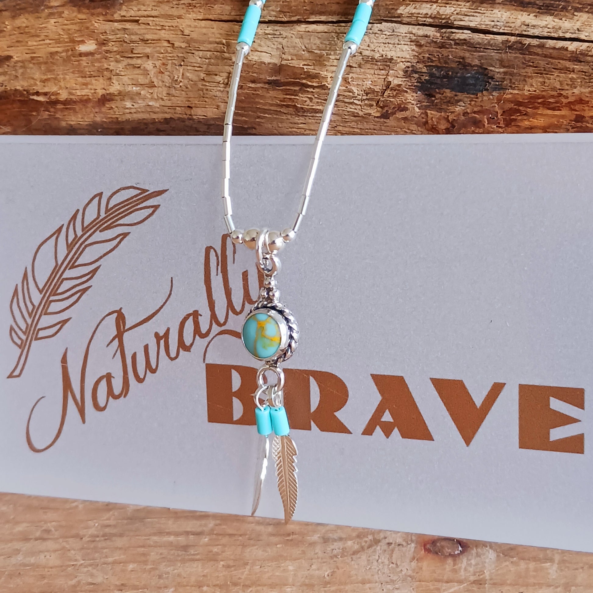 This Turquoise Silver feather necklace is a stunning piece of boho style jewellery featuring an authentic Native American design with a turquoise stone and two silver feathers. This beautiful pendant makes a meaningful gift, blending cultural heritage with personalized elegance.