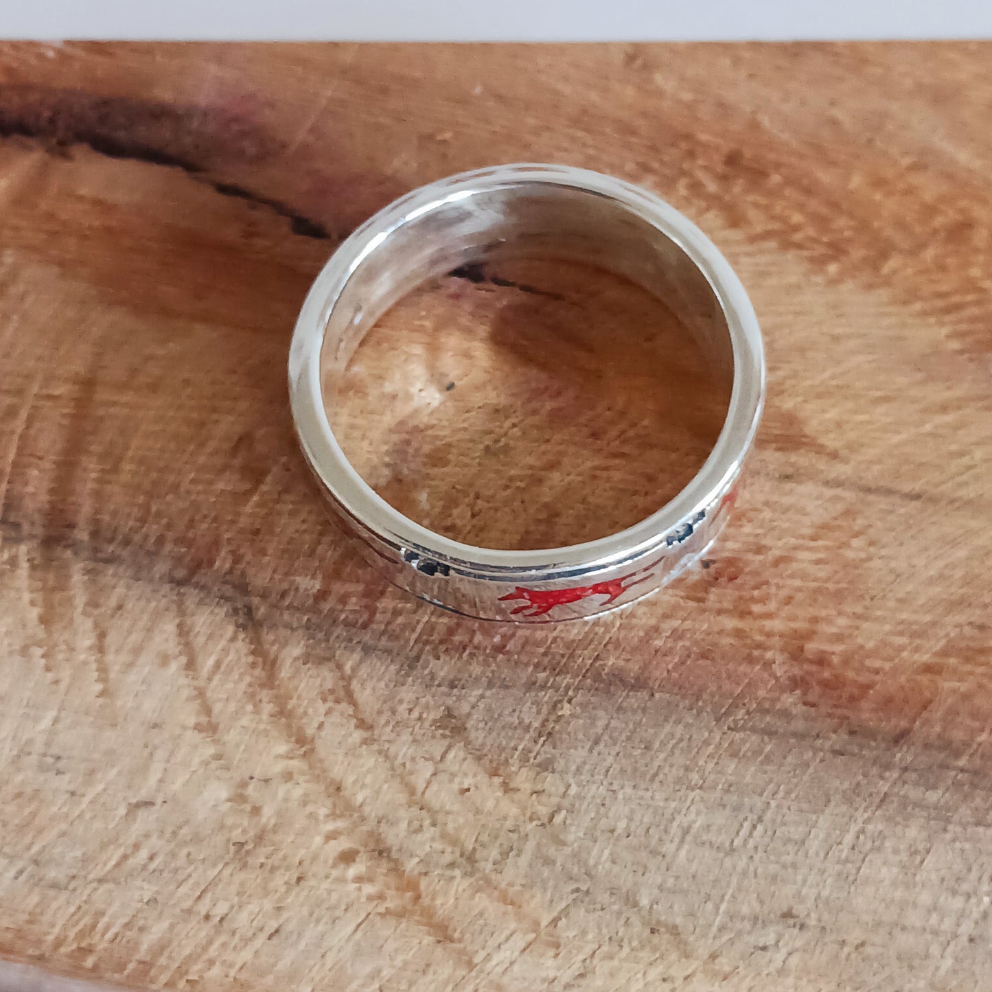 This solid sterling silver ring features a coral running wolf around the band. Southwestern Native-made Zuni jewellery embodies the rich cultural heritage and craftsmanship of the Zuni people, renowned for their intricate designs and meticulous attention to detail. Each piece is a testament to centuries-old traditions, handcrafted by skilled artisans who honor their ancestral techniques.