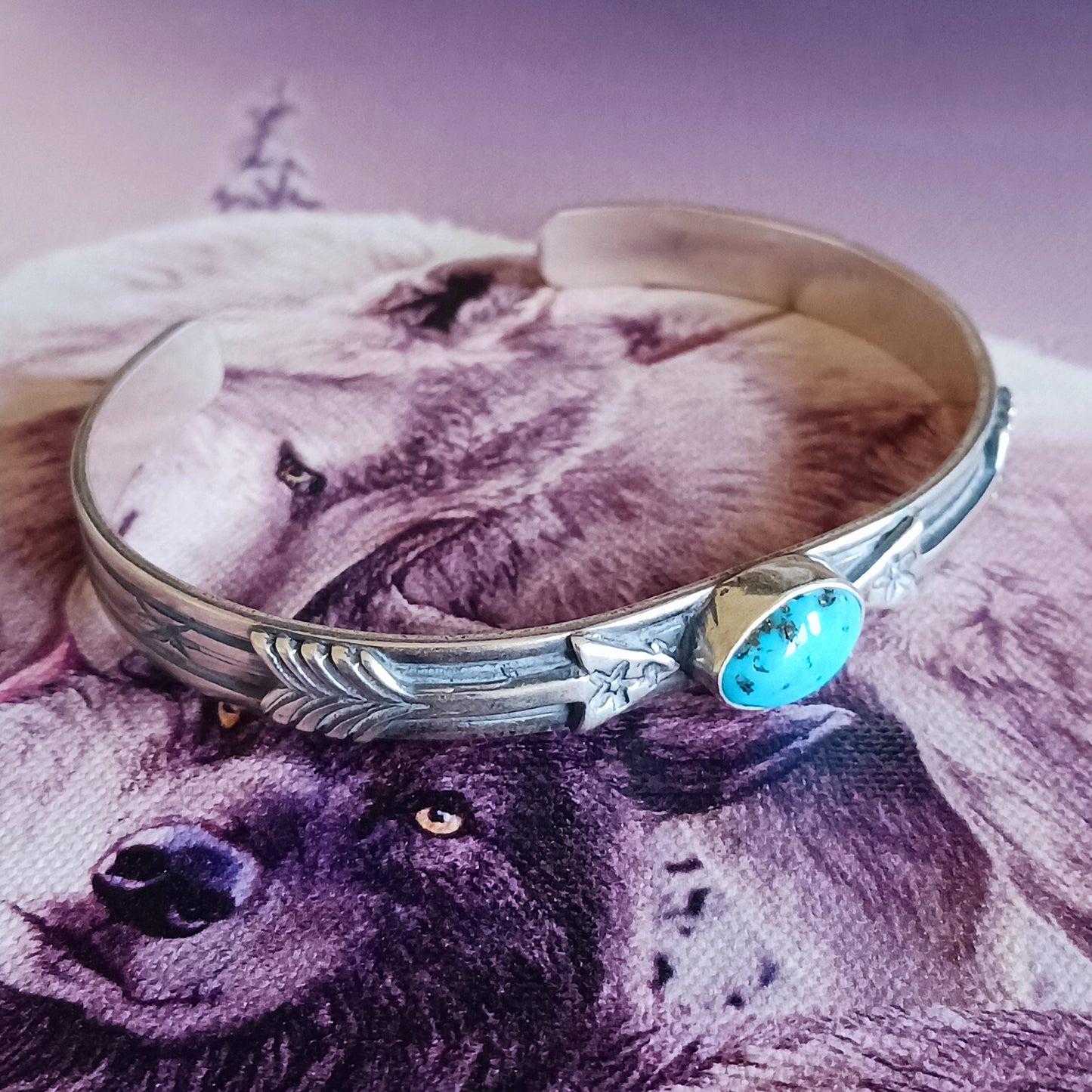 This bracelet is a stunning example of classic Navajo jewellery. This piece is handmade out of sterling silver and genuine Turquoise oval stone.  The Arrows are for protection.