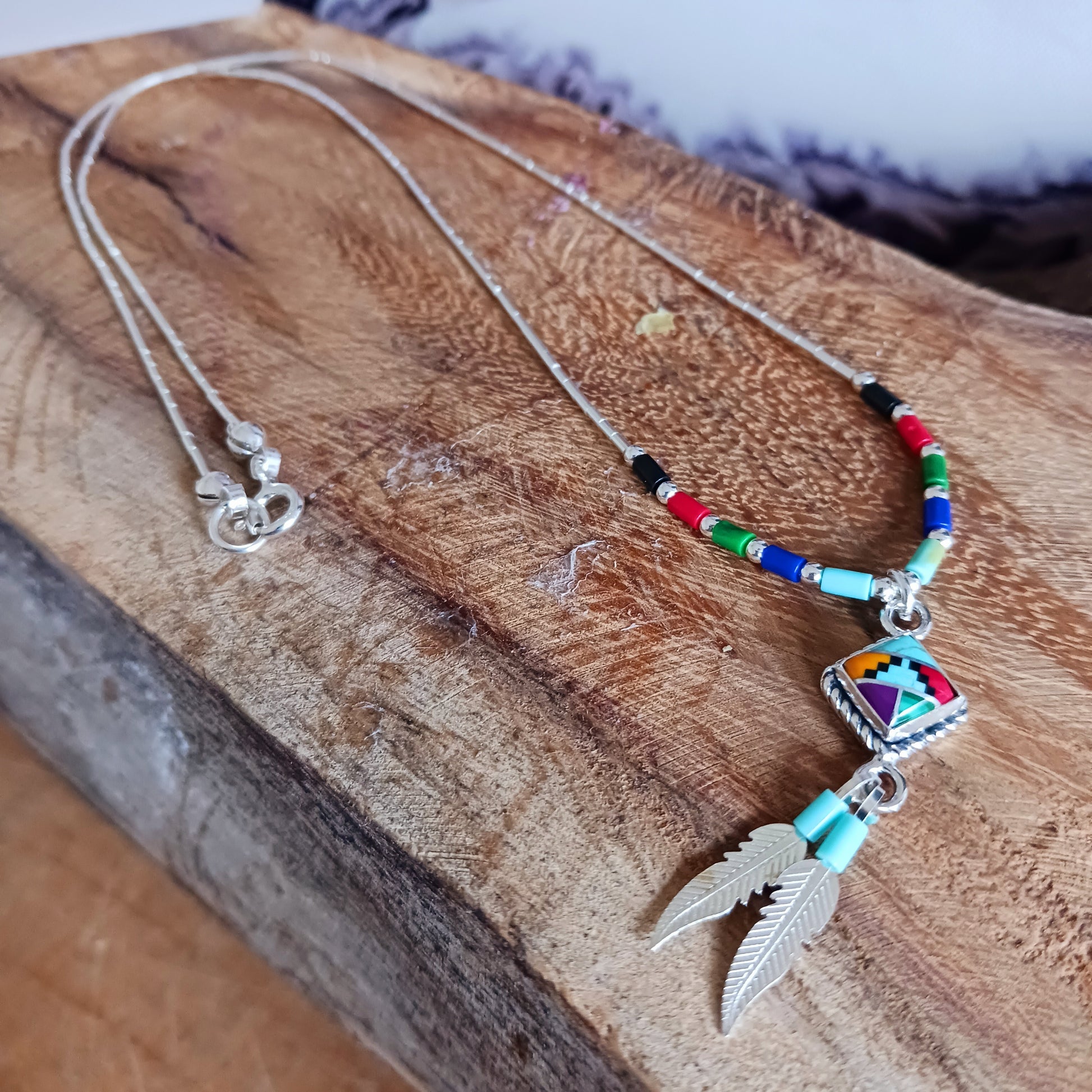 This stunning Aztec Necklace is both chic and cool. It has liquid silver chain with Aztec beads, the centrepiece is an Aztec diamond and from this hang two silver feathers, a symbol of warrior strength. 