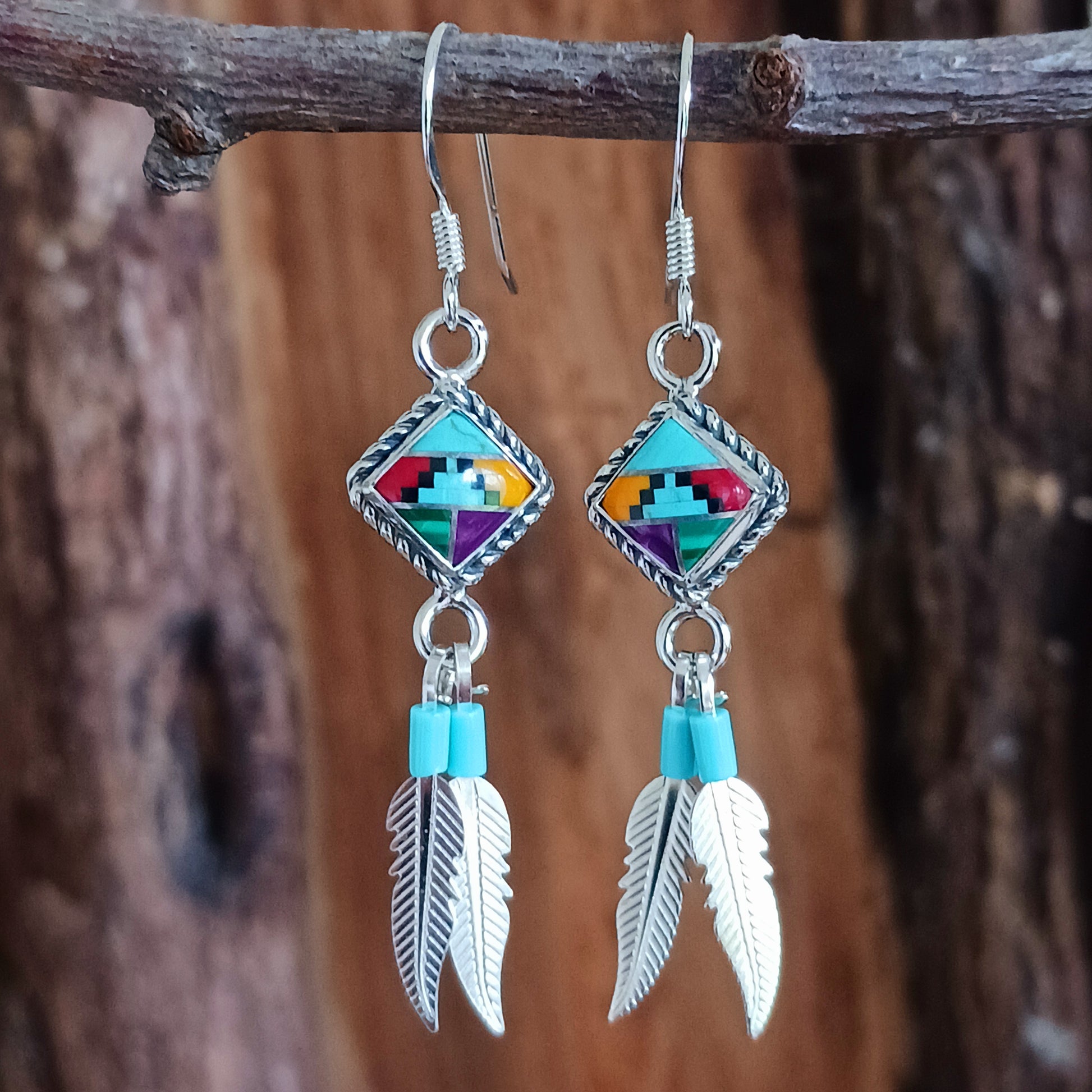 These stunning Aztec Earrings are both chic and cool. They feature a multicoloured Aztec diamond with rope surround, two silver feathers, on sterling silver ear wires.