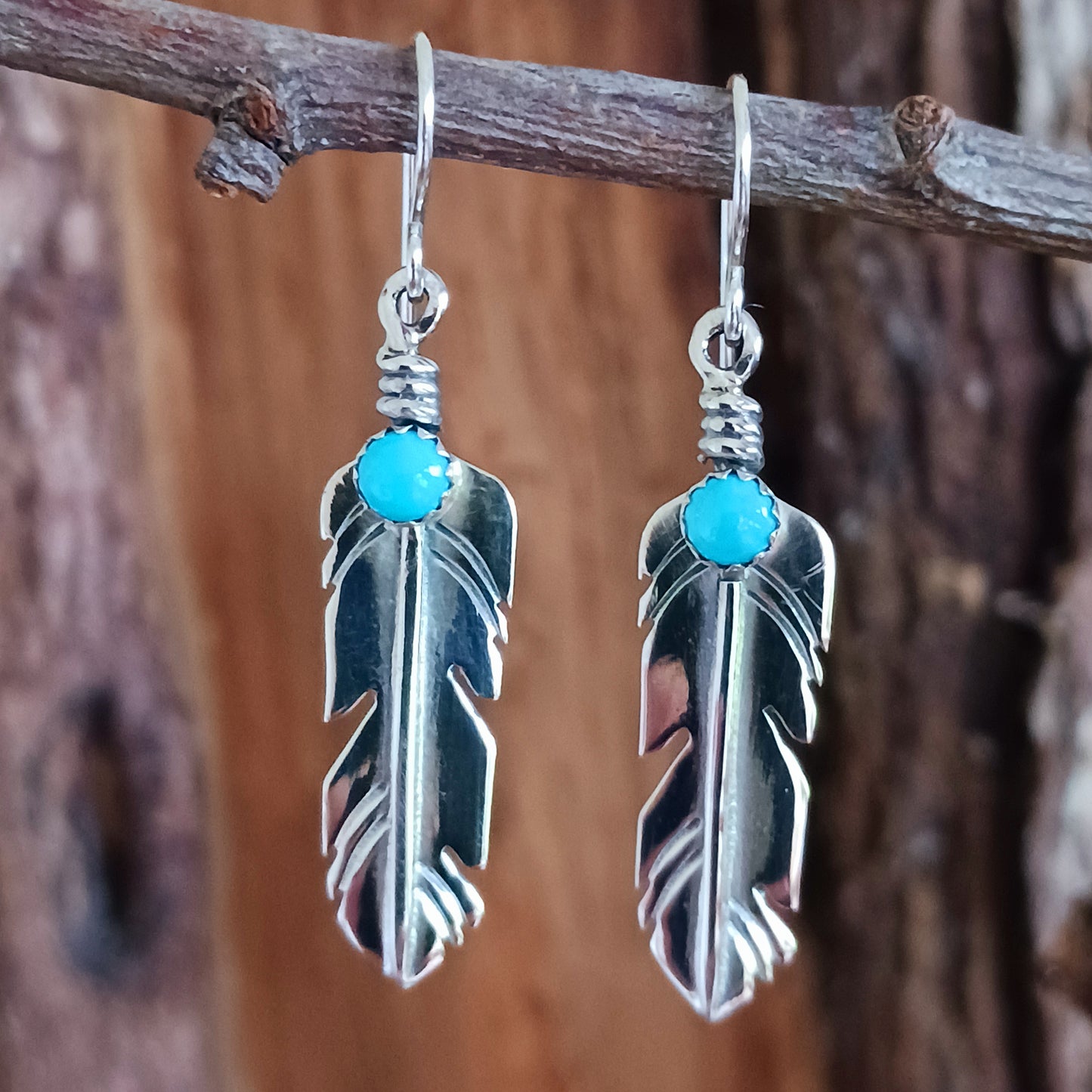 These are exquisite Navajo solid silver earrings, handmade by Navajo artist, Lula Nez. The feather earrings are hand cut with natural Kingsman Turquoise stone.  Feather is a totem of the all-powerful eagle and a gift of feather is a great honour.