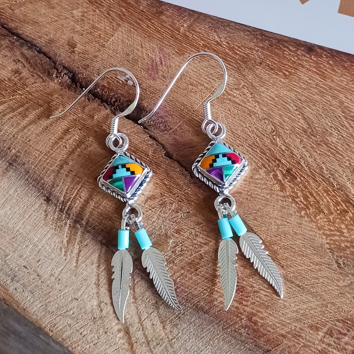 These stunning Aztec Earrings are both chic and cool. They feature a multicoloured Aztec diamond with rope surround, two silver feathers, on sterling silver ear wires.