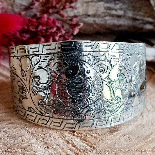 Handcrafted from Tibetan white metal, this elegant bracelet is delicately hand-etched with the Two Golden Fish - one of the eight Buddhist Auspicious symbols.