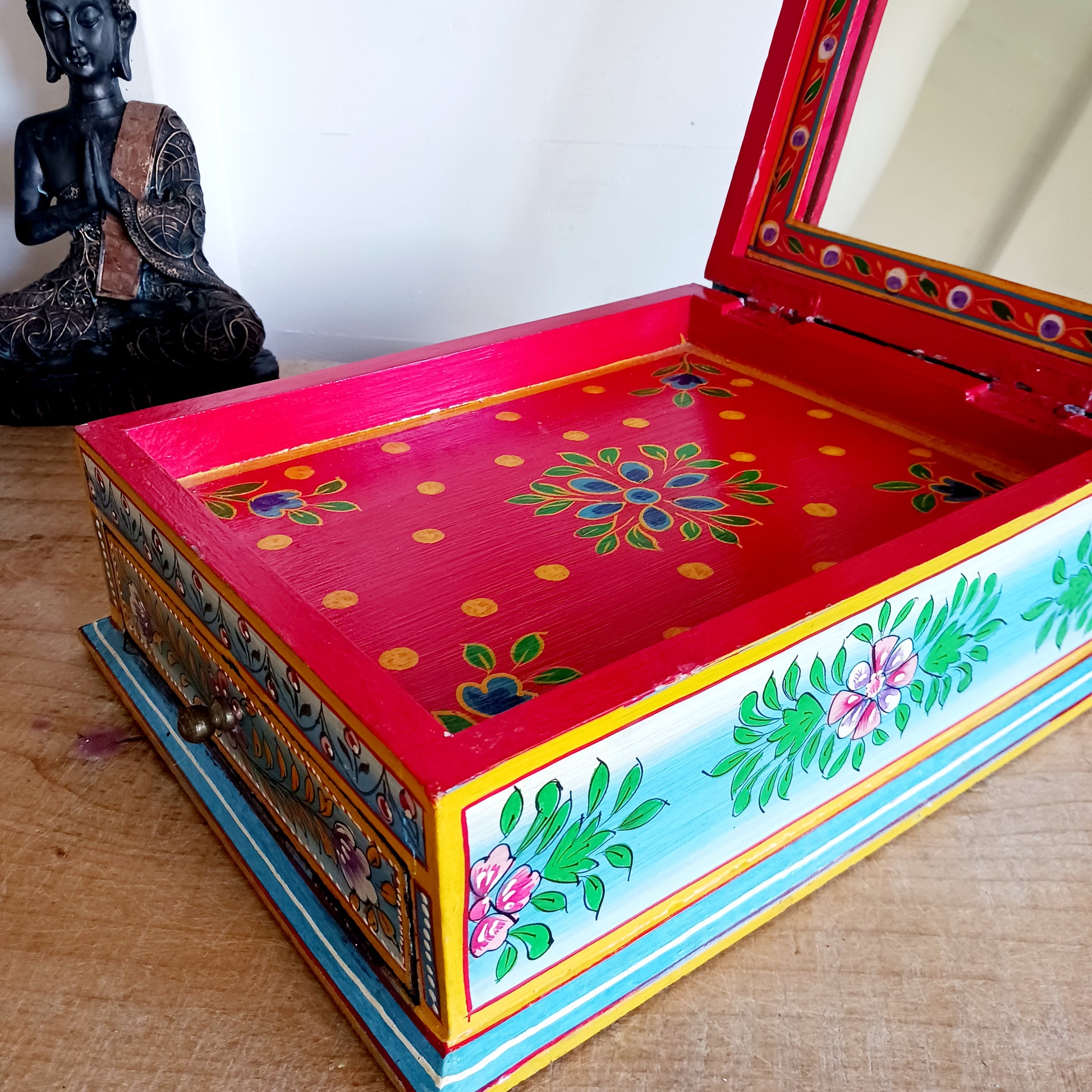 This stunning large Indian jewellery box has been hand painted to perfection in fresh spring-like colours of pastel blue, primrose yellow, pale pink and new season green.&nbsp; The elephant on the lid is in full ceremonial regalia and oval framed in yellow. It comprises a single drawer and top compartment opened by discreet round knobs.  A beautiful addition to any home.