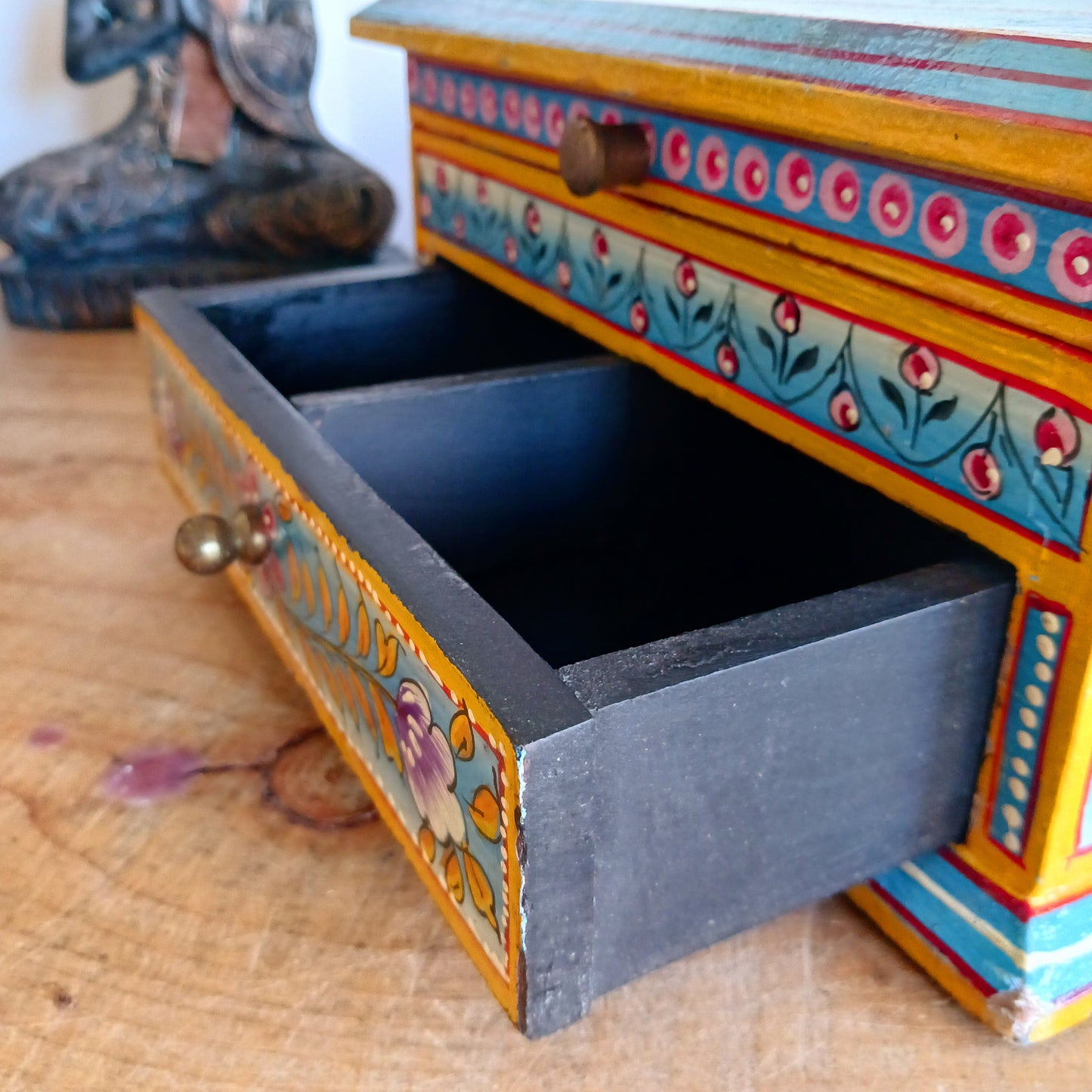 This stunning large Indian jewellery box has been hand painted to perfection in fresh spring-like colours of pastel blue, primrose yellow, pale pink and new season green.&nbsp; The elephant on the lid is in full ceremonial regalia and oval framed in yellow. It comprises a single drawer and top compartment opened by discreet round knobs.  A beautiful addition to any home.