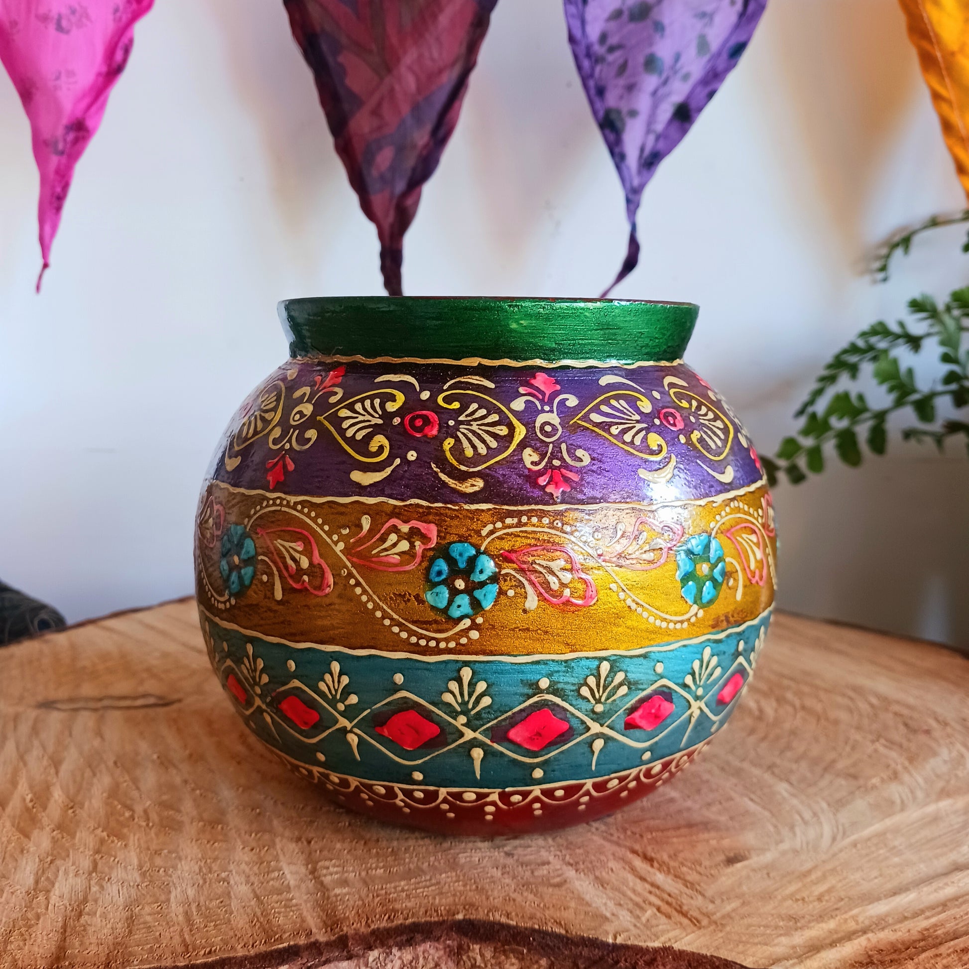 This decorative vintage style wooden pot has a detailed hand painted design. The attractive rich colour combination is set off with a pretty gem embellishment, adding texture and visual delight. An impressive entrance feature as ornamental storage or fill with dried grasses for an organic, changeable room feature.