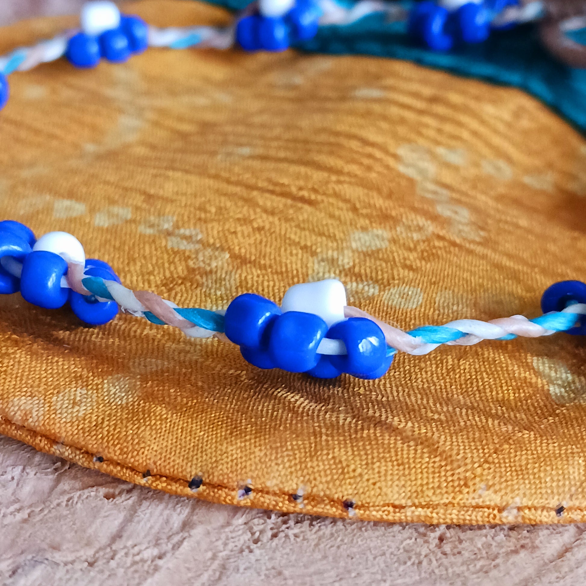 These pretty daisy anklets are made from a collection of beads and and plaited string. They each have a secure fastening and are a great addition to any summer wardrobe.