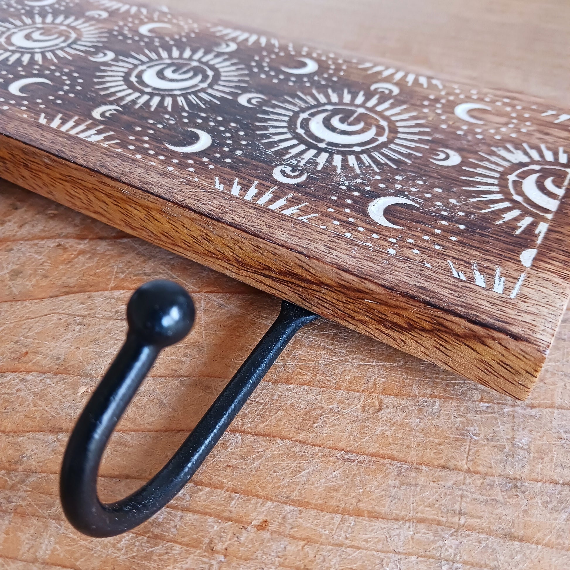 This wall mounted key hook or coat hanger has been hand carved from mango wood and decorated with crescent moons design, etched and painted white with 3 hooks for hanging. There are 2 hooks at the top on back from which to hang.