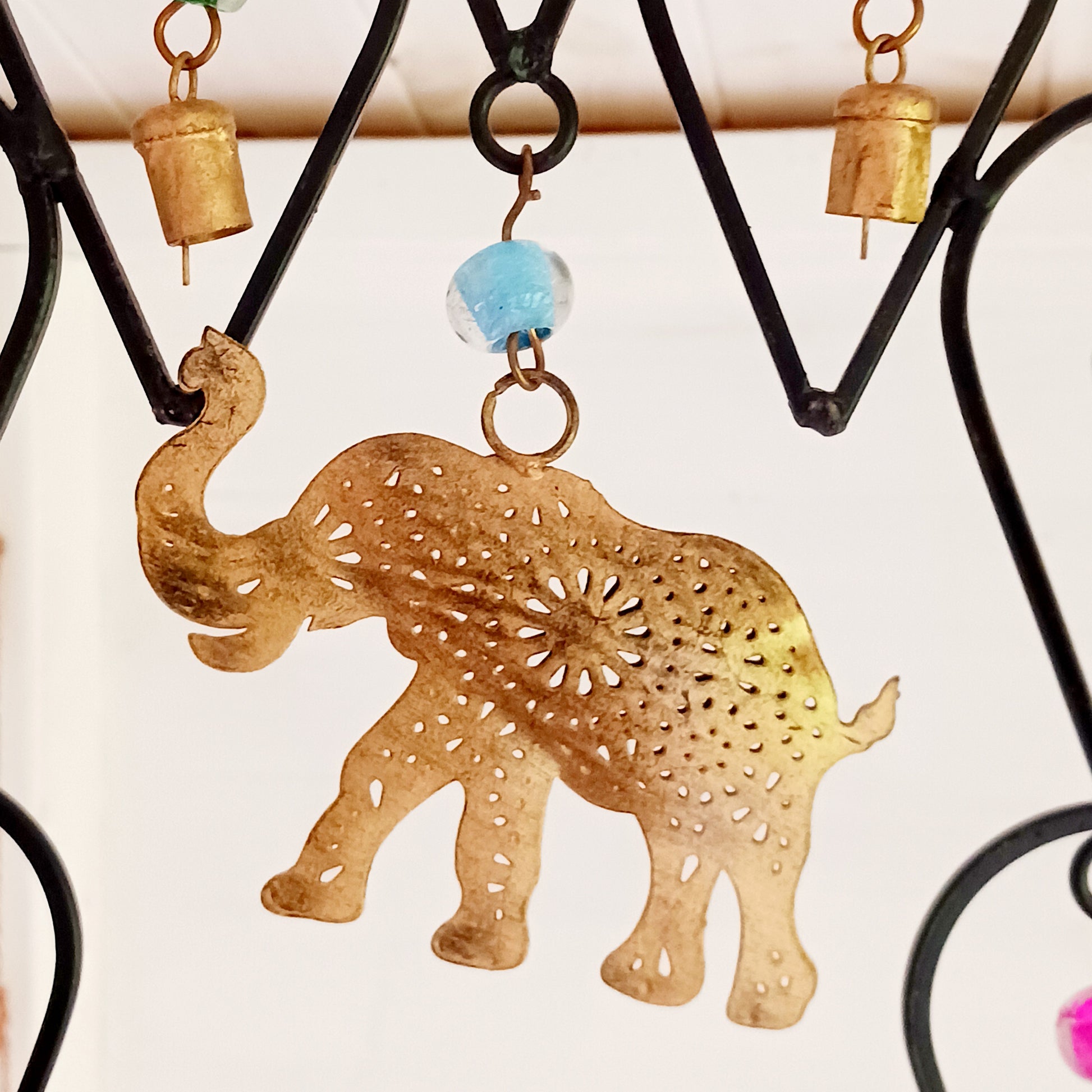 This beautiful windchime has been handmade in Northern India from recycled iron, utilising traditional iron-working skills. At the centre features an elephant image depicted with an upturned trunk, this is widely considered a symbol of good luck. The windchime is also decorated with Indian bells and colourful glass beads. The bells make a lovely, musical sound in a gentle breeze.