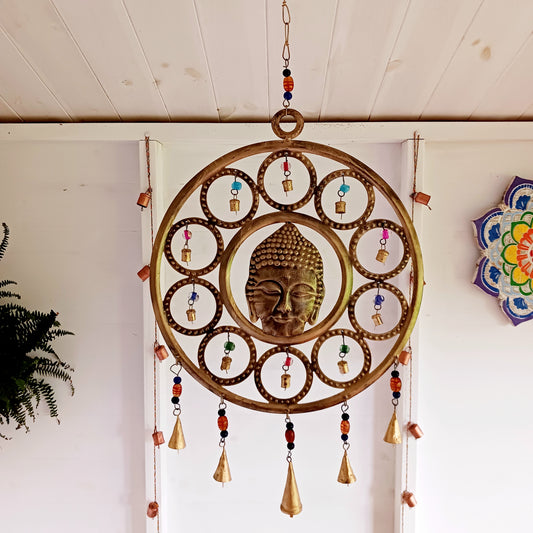 Enhance your living space with this beautiful large Buddha face 15 bell chimes. This lovely 36 cm brass decoration exudes serenity and spiritual charm. An intricate piece featuring a serene Buddha face surrounded by delicate circular accents and vibrant, colourful beads. With 15 brass bells, this chime creates a harmonious, soothing sound, making it ideal for both indoor and outdoor spaces.