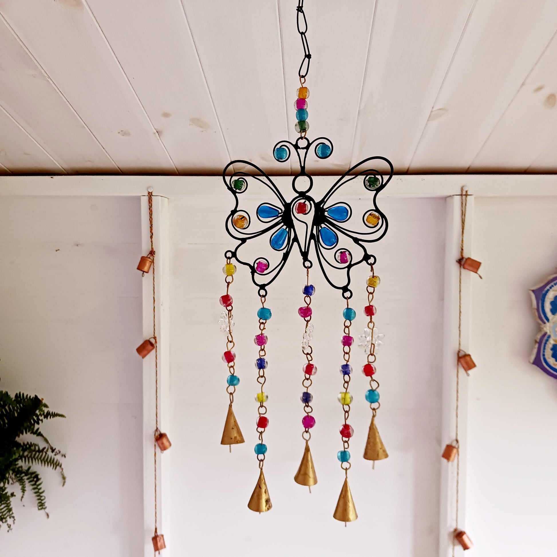 This pretty Butterfly windchime is decorated with vibrant mixed beads and Indian bells. Handmade from recycled iron, the bells make a lovely light tinking sound in a gentle breeze. Ideal for both inside the home or in your garden.