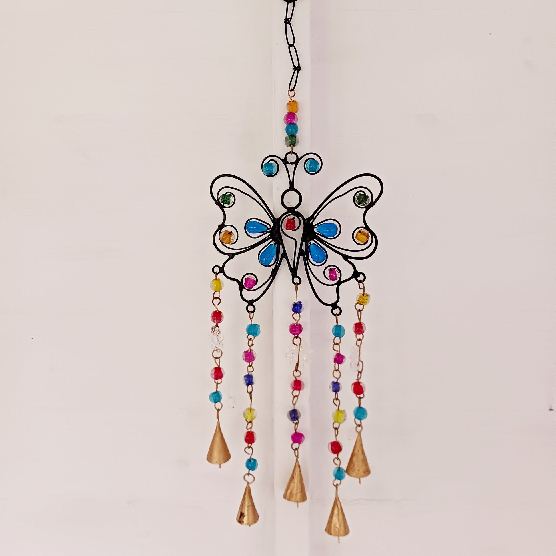 This pretty Butterfly windchime is decorated with vibrant mixed beads and Indian bells. Handmade from recycled iron, the bells make a lovely light tinking sound in a gentle breeze. Ideal for both inside the home or in your garden.