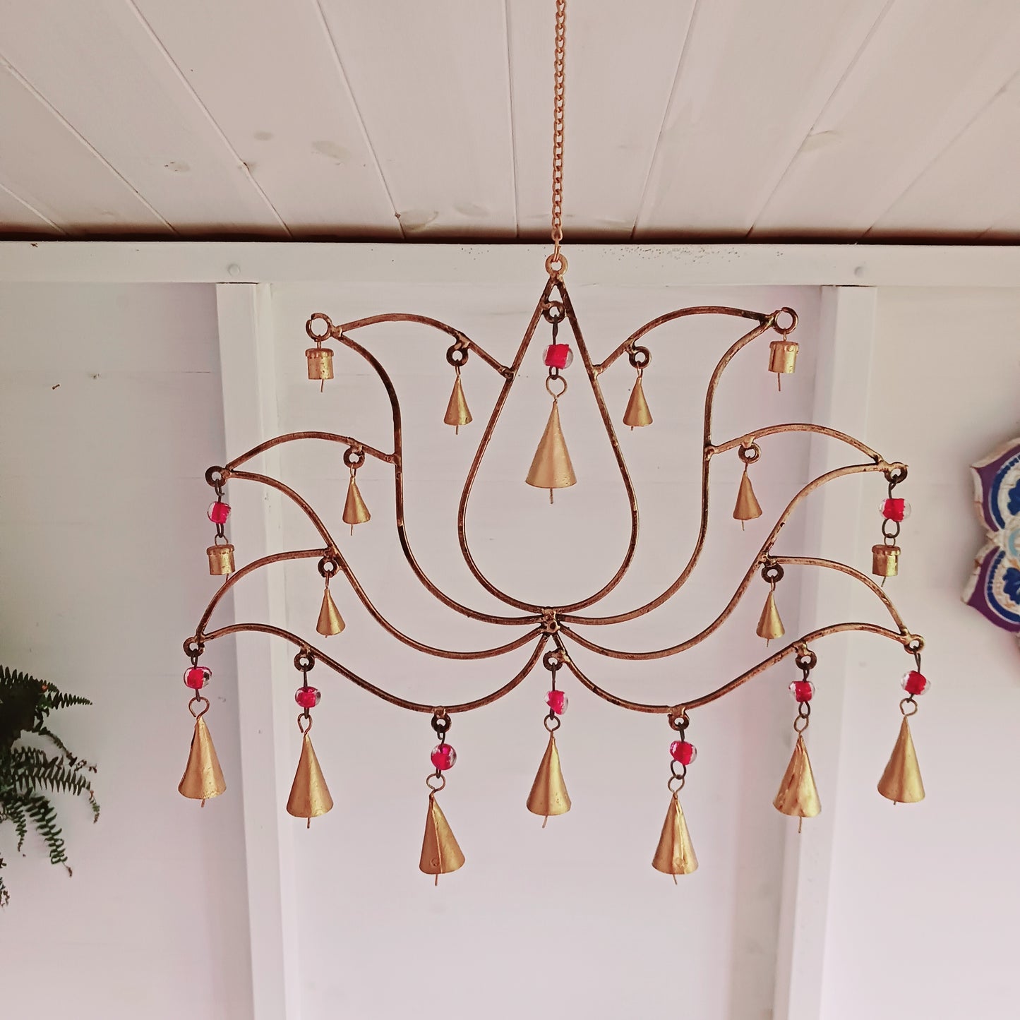 This unusual windchime has been handcrafted from recycled iron in the shape of a Lotus flower. There are 18 hangings, each with an Indian bell at the bottom. The recycled metal gives the windchime a wonderful rustic look, and the Indian bells make a lovely sound in a gentle breeze.