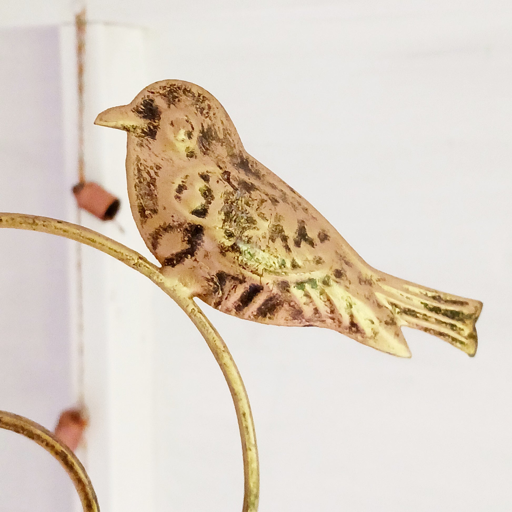 This lovely windchime is features a large metal heart that encloses a smaller heart, that in turn, holds an Indian decorative bell. Perched on the top of the windchime sit a pair of feather detailed birds. The hanging windchime decoration has a mounting chain and is completed by 7 Indian bells on the bottom edge; the largest bell in the centre.