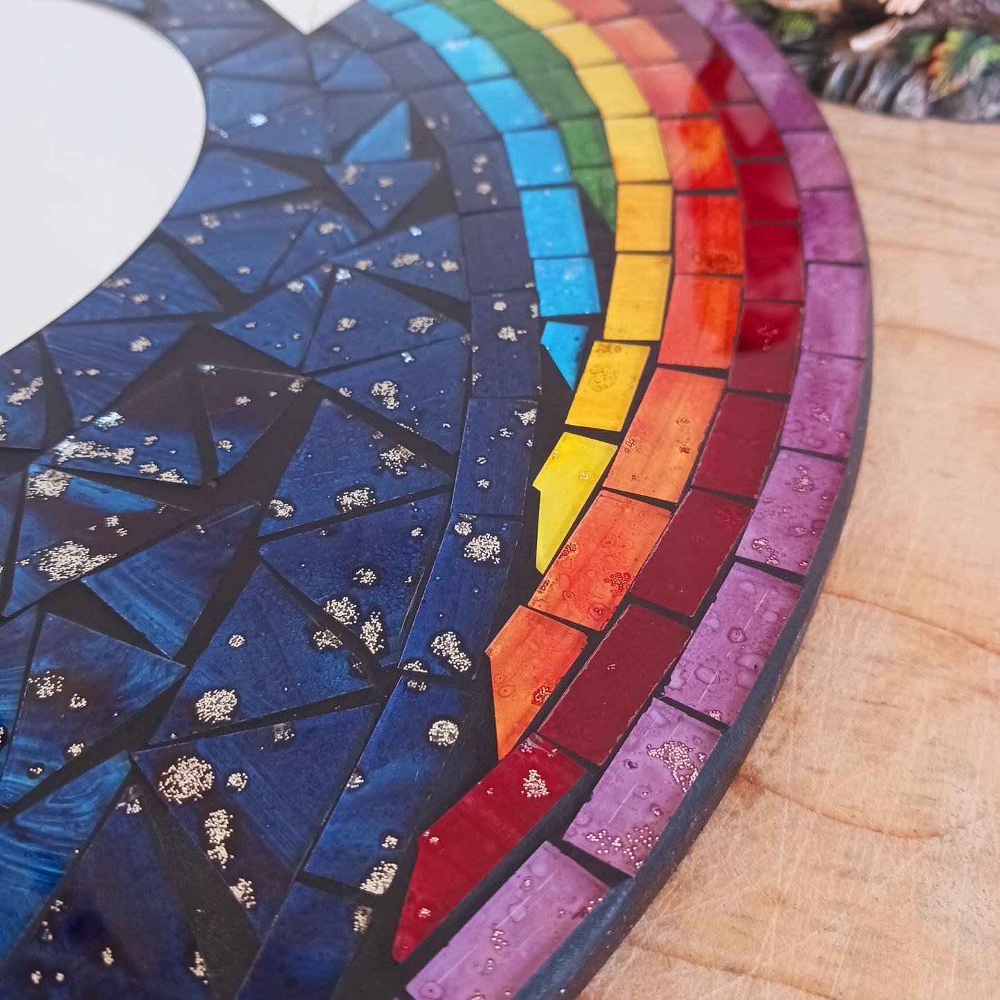 This bright and decorative round mirror is adorned with colourful mosaics creating a wonderful design of rainbow shooting stars flying through the night sky. 