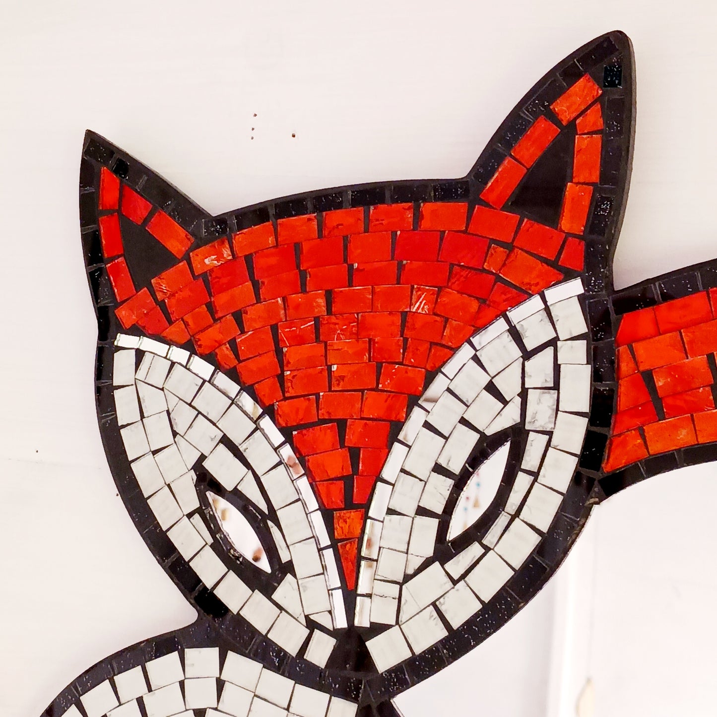 This lovely curled fox mirror has been handmade using small pieces of coloured glass to create a beautiful mosaic piece. There is an easy hanger on the back. Perfect for displaying on any wall in your home.