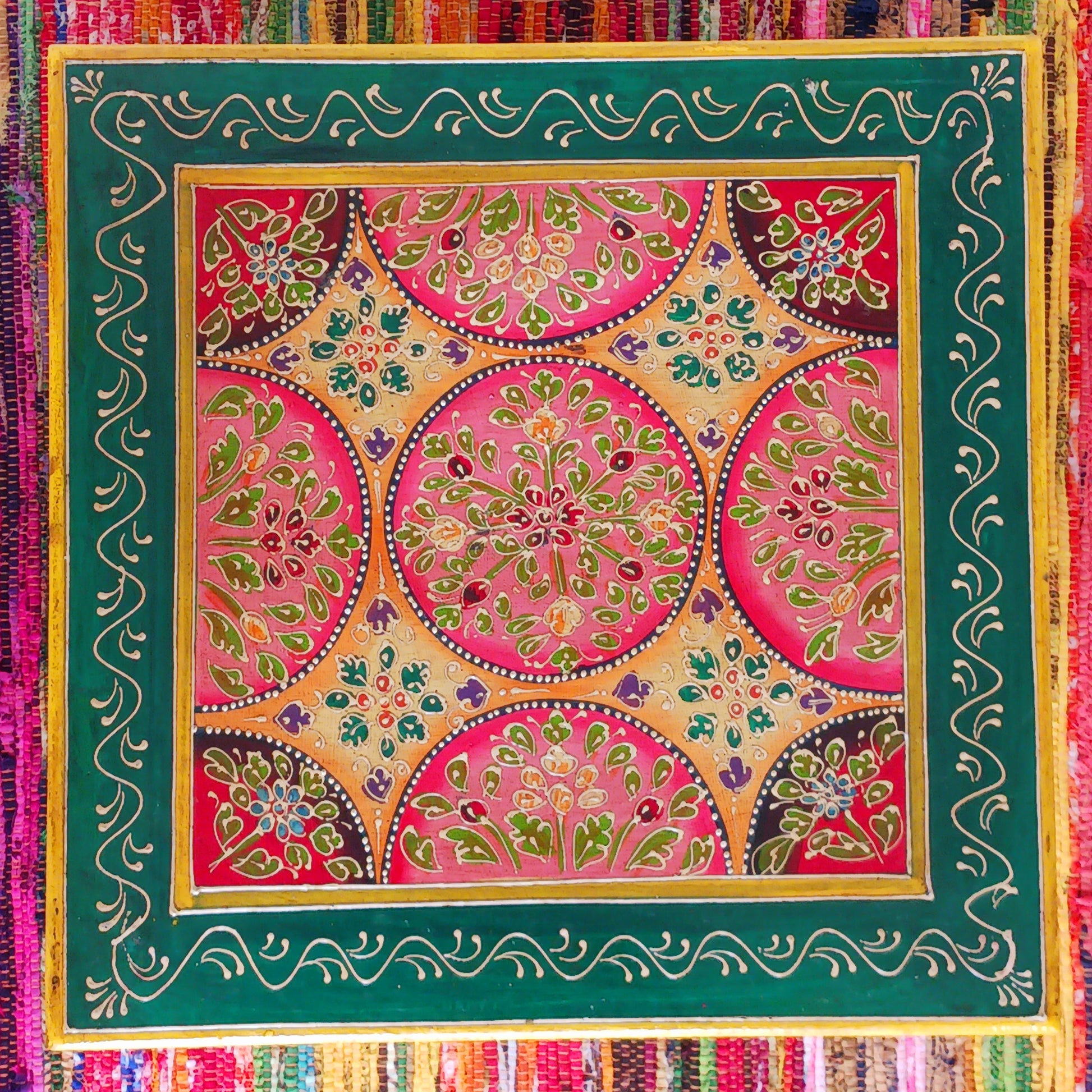 Bring a touch of Indian vibrance to your home with this stunning hand-painted pink and lime bajot table.  Hand crafted from solid wood and decorated with eye-catching Indian motifs, this lovely piece of furniture makes a charming coffee table or unique accent piece.