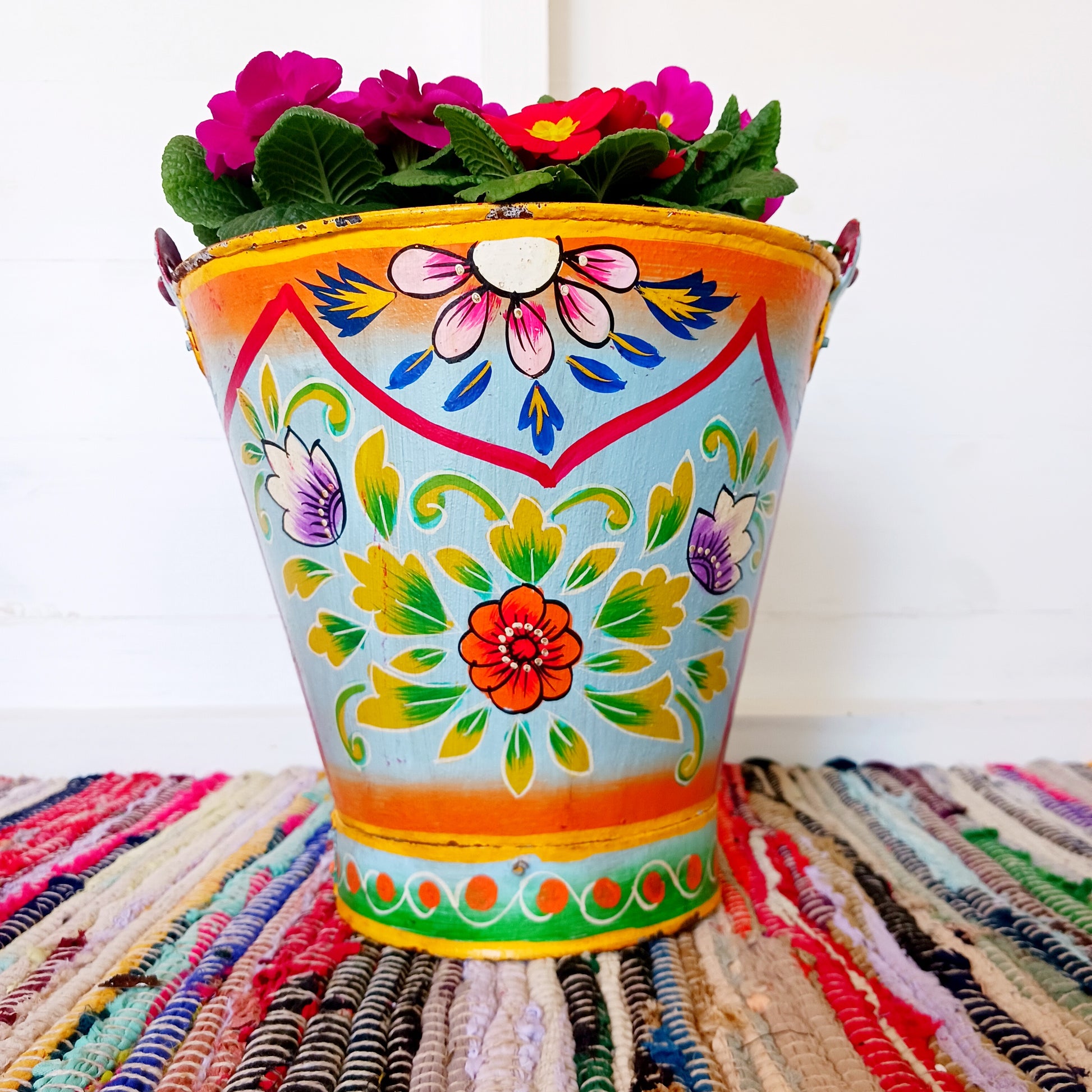 Hand painted in a turquoise floral design, a vintage style iron plant pot to display as a decorative indoor/outdoor planter. Lovingly hand painted by skilled artisans on a fair trade basis in the Indian desert city of Jodhpur. Fill the striking container with a flowering or contrasting potted plant. Grow seasonal bulbs to bring life and inspiration.