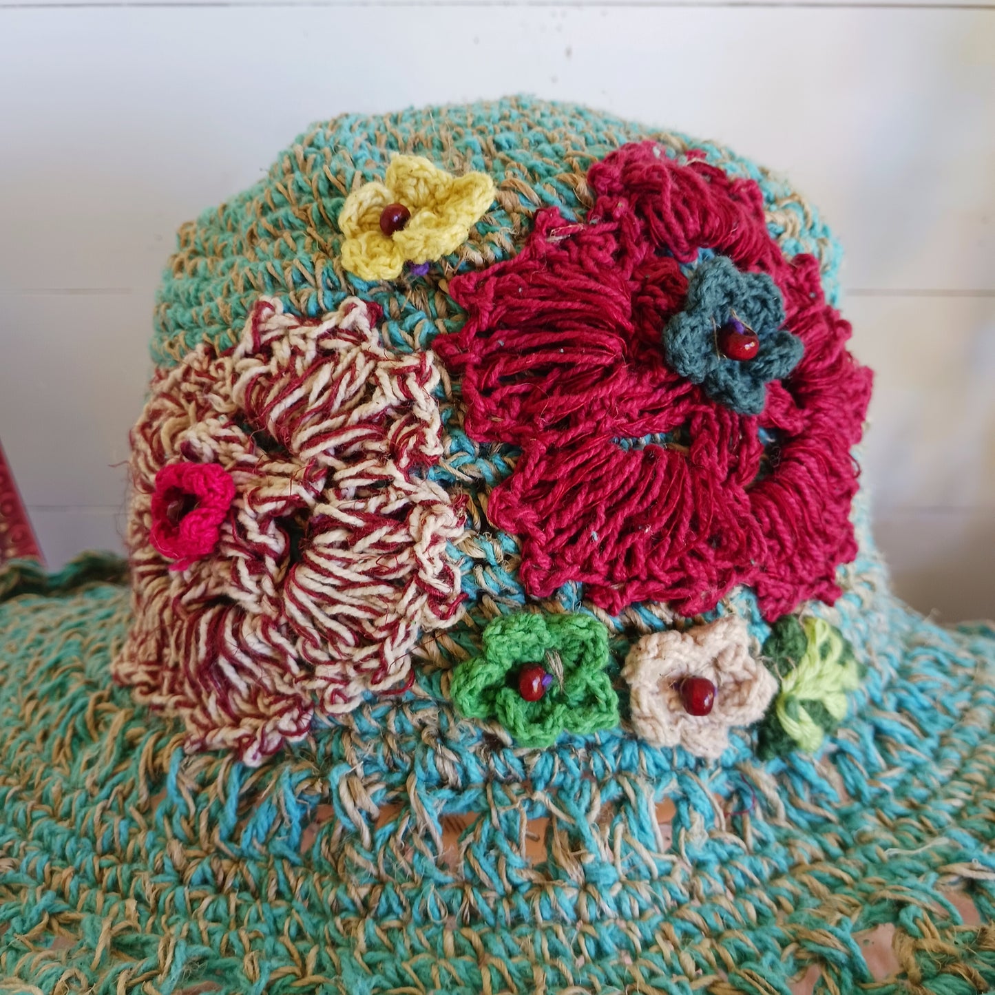 Handmade hemp & cotton boho festival hat with crochet flowers. A unique accessory that beautifully embodies the free-spirited essence of Bohemian style. Handcrafted with care and creativity, each of these hats is a harmonious blend of hemp and cotton, resulting in a distinctive piece that exudes both fashion and sustainability. They're ideal for music festivals, beach outings, or simply just to brighten up any outfit.
