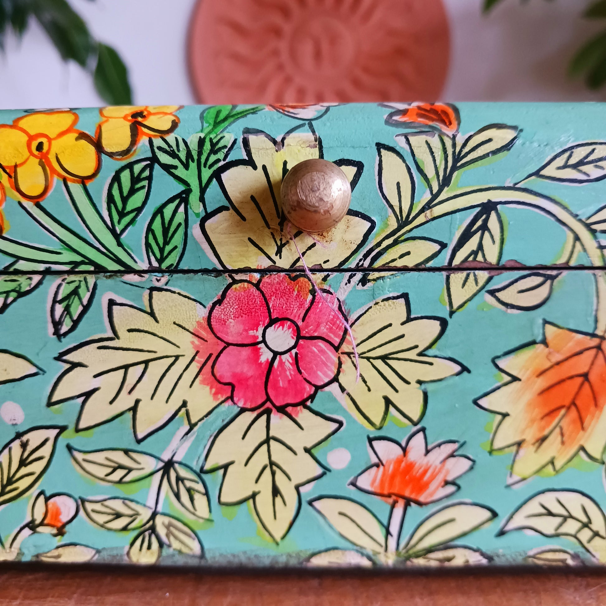 The Saanvi Handcrafted Small Wooden Box is a sustainable gift of beauty, designed to bring charm and practicality to any space. Expertly hand-painted in a bright mixed floral pattern on a pale blue background, this decorative box exudes artisanal elegance.