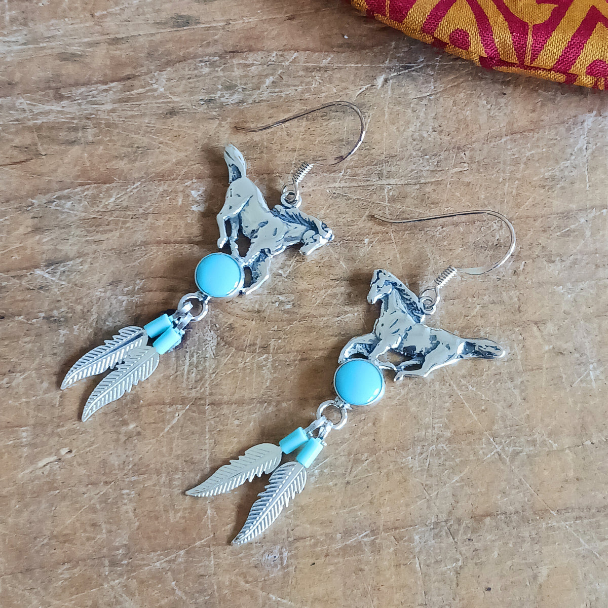 Add a touch of timeless beauty to your jewellery collection with these Sterling Silver and Turquoise Stallion Feather Dangle Earrings. Handmade in a Native American-inspired style, these attractive earrings combine the elegance of solid 925 sterling silver with the natural beauty of genuine turquoise gemstones.