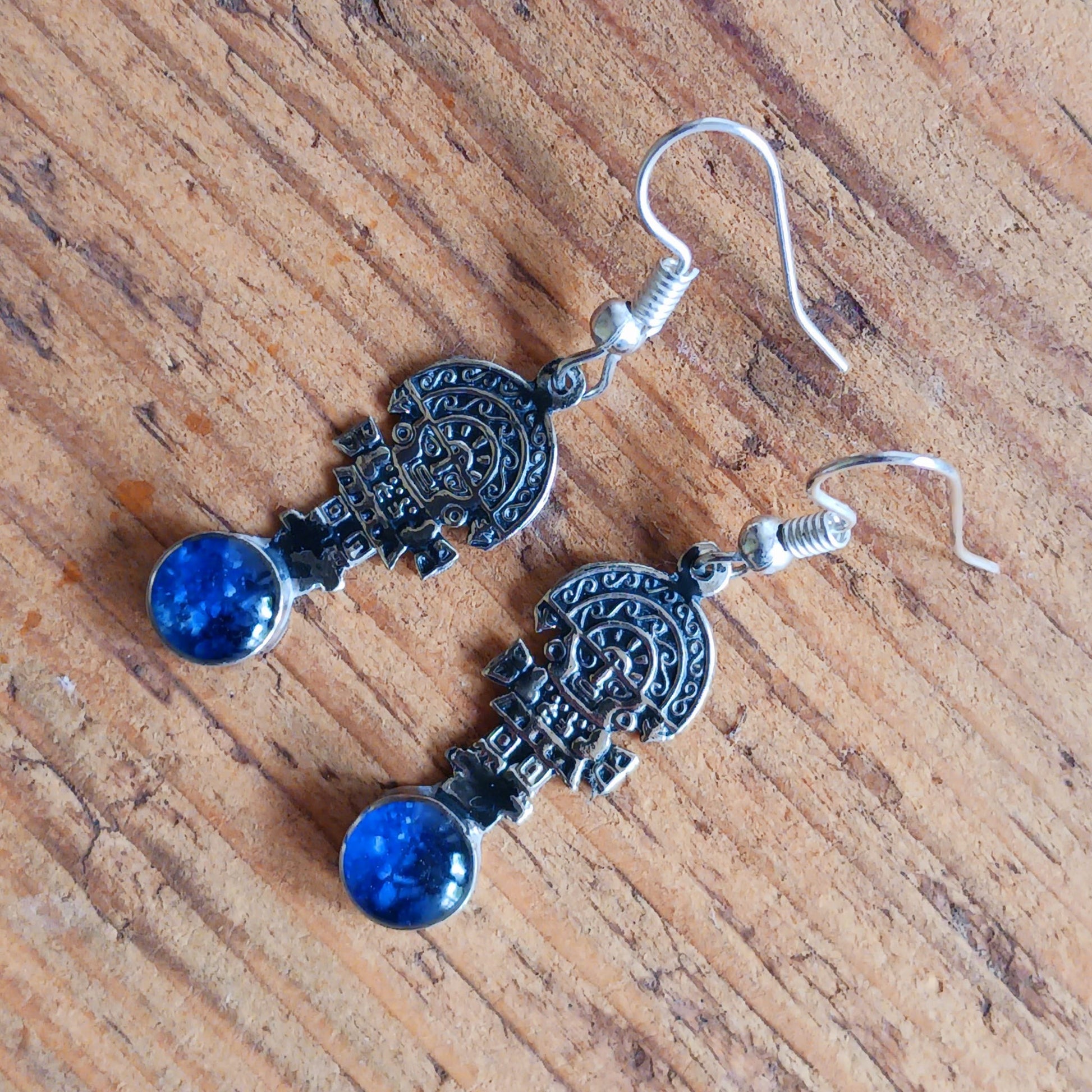 These intricate earrings feature a tiny image of the Tumi, a type of ceremonial knife used in ancient Peru by the Moche culture. &nbsp;They feature a mythical character usually identified with the god Naymlap.&nbsp;  All hooks are silver plated and these earrings come with crushed lapis lazuli stone.  Ideal for a night out, for dressing up your boho look or as a gift for family or friends.