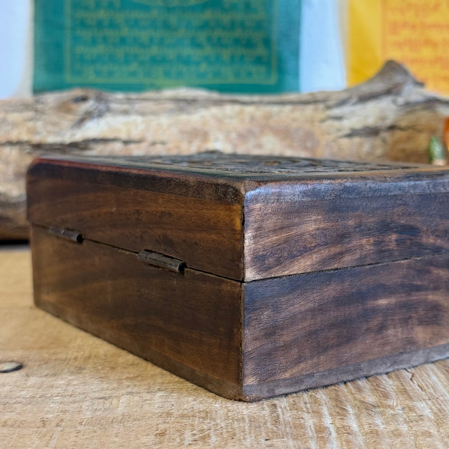 A lovely little hand carved Mango wood wooden box Hand carved in India It has a little brass fastening at the front, perfect for keeping your trinkets and keepsakes safe. Discover the beauty of hand carved craftsmanship from India with our Square Wooden Keepsake Box Om. Each box is carefully made from mango wood and features a charming brass fastening at the front. Keep your precious trinkets and keepsakes safe in this sturdy and stylish box.

Size is approx. 15 x 10 x 6 cm

Handmade in India