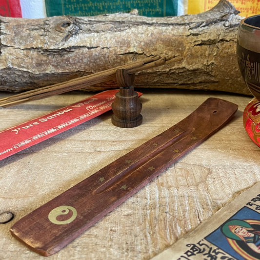 Introducing our best-selling incense holder: a beautifully crafted shoe horn-style ash catcher made from premium mango wood. Designed for stick incense, this elegant piece features charming inlays of stars and a symbolic Yin Yang.