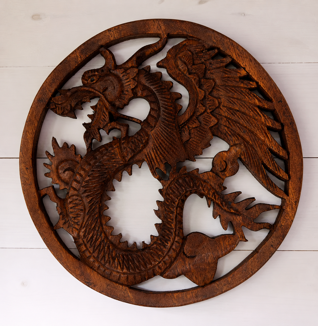 Bring strength, wisdom and timeless craftsmanship into your home with this hand carved Wooden Dragon Plaque. Expertly crafted in Indonesia from sustainably sourced wood, each plaque features an intricate dragon design inspired by ancient folklore and cultural traditions. Dragons have long symbolised protection, courage and guardianship across many cultures, making this striking wall hanging a meaningful addition to any living space. Every piece is individually carved by skilled artisans under Fair Trade con