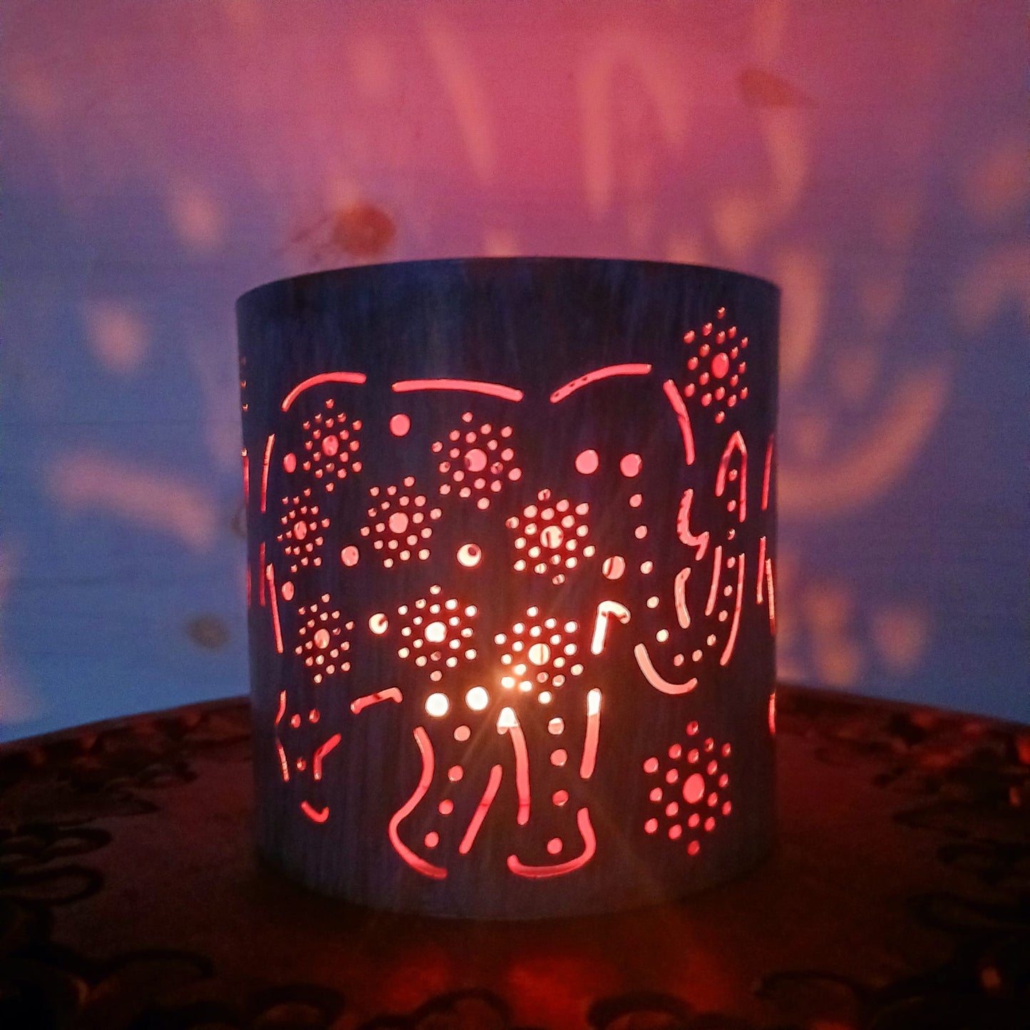 This lovely Fairtrade, blue and gold vintage look Tea-light holder has decorative Elephants around the sides and gives off a wonderful atmospheric glow. It is suitable for burning tealights and other small candles, holding three at a time.