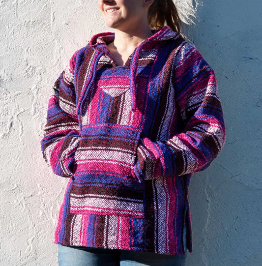 Wrap yourself in warmth and colour with this Mexican Pink Baja Top, a vibrant expression of bohemian spirit and ethical craftsmanship. The bold blues and pinks weave together in a striking pattern that reimagines the classic Baja design for the modern free soul.

Each hoodie is ethically sourced from Mexico, where skilled artisans create them with care, ensuring fair wages and safe working conditions. The soft, brushed interior offers comfort against the skin, while the relaxed, unisex fit makes it perfect 