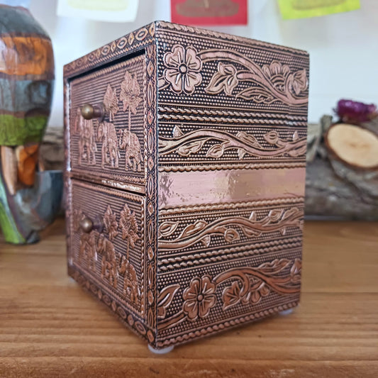 This lovely and unusual 2 drawer chest can be used as a jewellery or trinket box. It's lined in cotton velvet and decorated with intricate elephant images and patterns covering the whole box. It has delicate little pull handles on each drawer. A beautiful item made from rose gold aluminium.