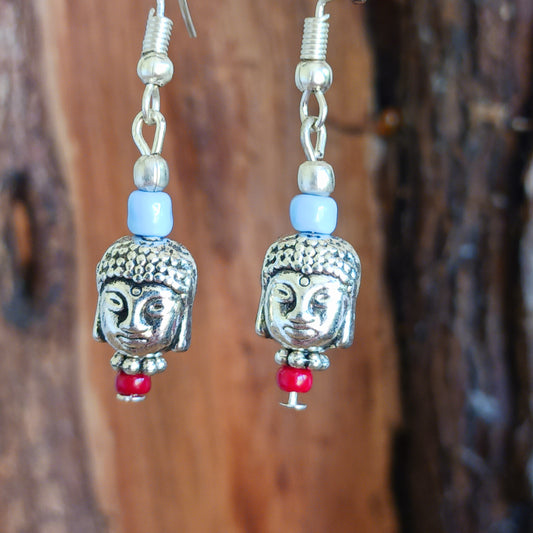 These pretty and intricate dangly earrings feature Buddha heads, decorative beads in blue and red and are hung on silver plated hooks. Gifted in a traditional Tibetan pouch.