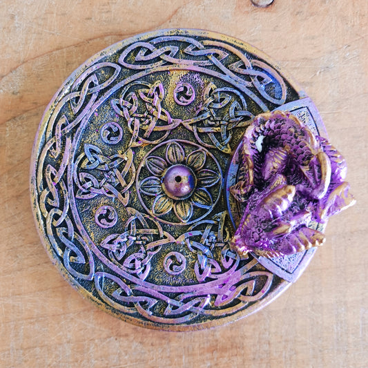 Embrace mystical vibes with this enchanting Celtic dish incense holder featuring a whimsical baby dragon. Crafted with intricate detail, the baby dragon perches atop the dish, its scaled wings unfurled in a protective stance. The Celtic design adds an aura of ancient magic, perfect for any altar or sacred space.