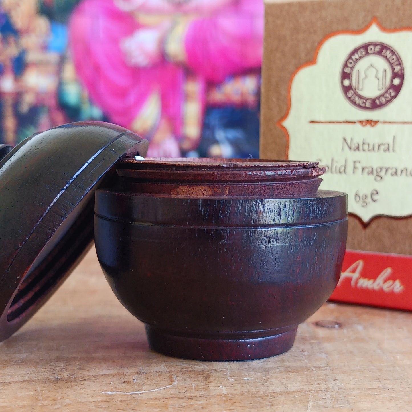 Experience the timeless beauty of jasmine with this luxurious Song of India Amber Fragrance Cream, beautifully housed in a handcrafted rosewood jar. Made by skilled artisans using carefully selected Indian rosewood bark, each container showcases unique natural grain patterns, colours, and veins, making every piece a one-of-a-kind collectible.