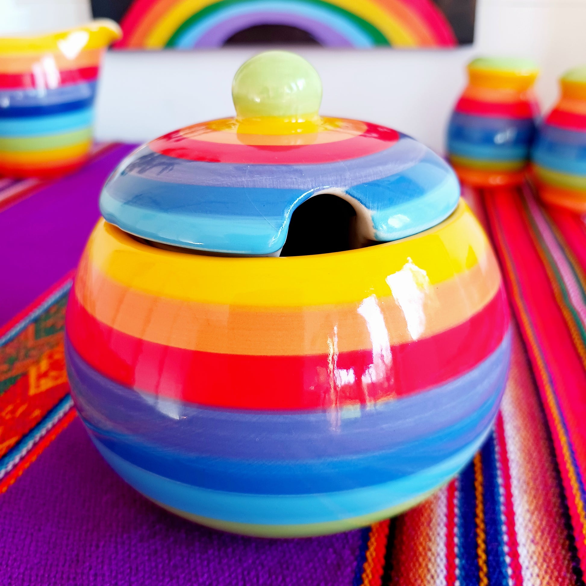 Add a splash of colour to your home with this Rainbow Stripe Ceramic Sugar Bowl.  The vibrant, hand-painted stripes create a cheerful aesthetic, while the artisanal craftsmanship ensures every piece is uniquely charming. Perfect for serving sugar or small treats, this sugar bowl brightens any table setting.
