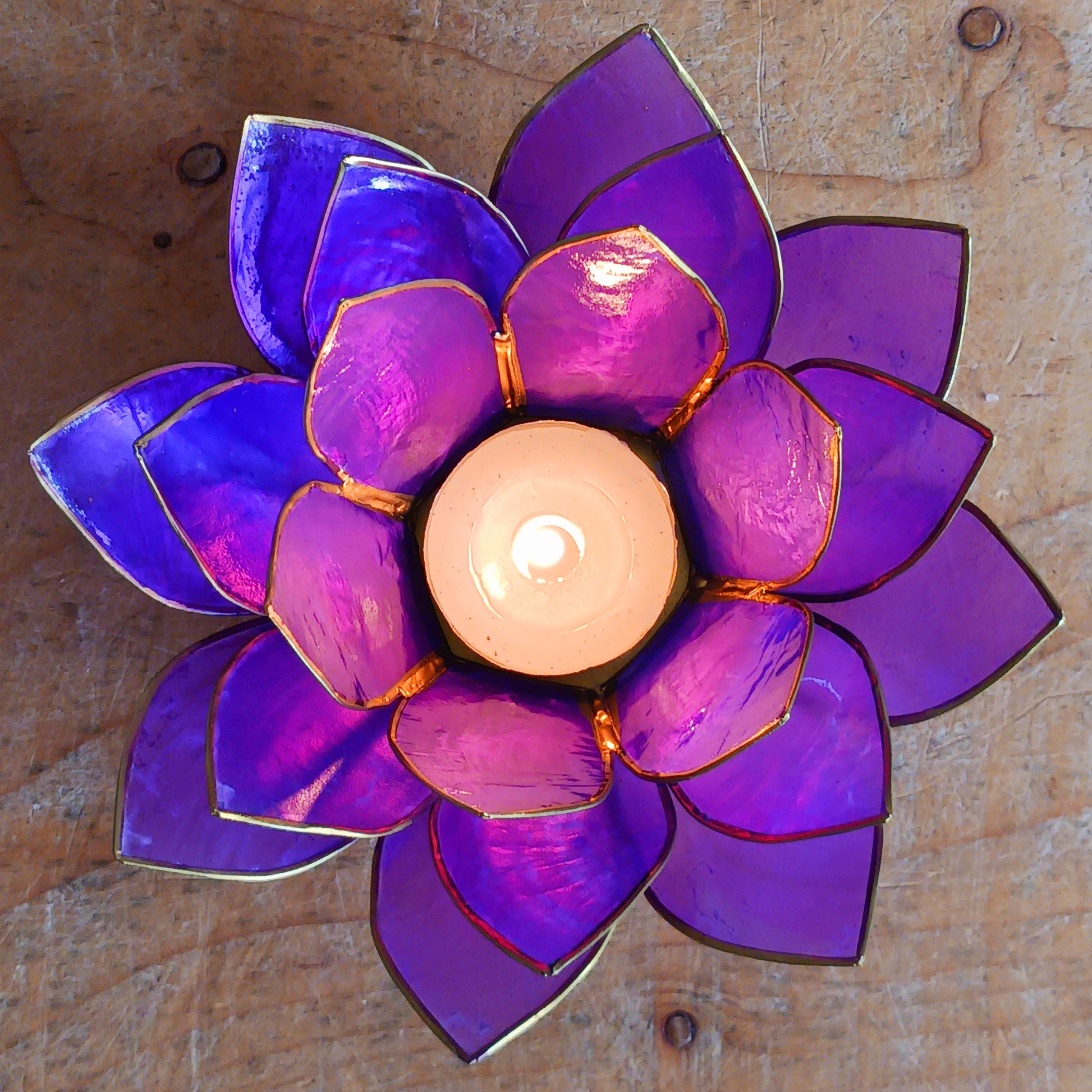 Illuminate your space with the peaceful elegance of our Capiz Shell Lotus Flower Candle Holder. Symbolizing enlightenment and serenity, this stunning handcrafted piece features delicate purple petals edged in gold, forming the iconic lotus shape. When lit, the layered design diffuses candlelight into a soft, radiant glow — ideal for creating a calming ambiance indoors or outdoors.