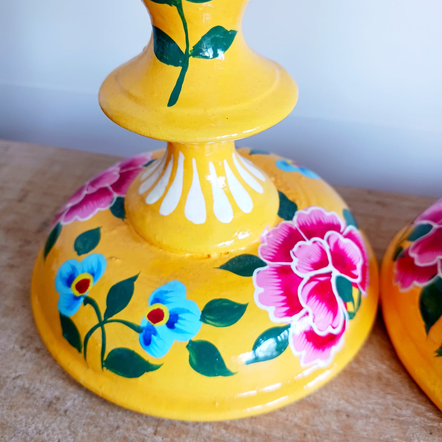 Add warmth, colour, and artisan beauty to your home with these hand painted yellow wooden candlesticks, beautifully crafted from sustainably sourced wood. Each piece is carefully painted by skilled artisans and decorated with elegant chrysanthemum flowers, a symbol of positive life forces including love, appreciation, longevity, happiness, and optimism.