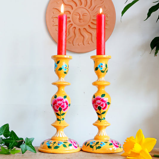 Add warmth, colour, and artisan beauty to your home with these hand painted yellow wooden candlesticks, beautifully crafted from sustainably sourced wood. Each piece is carefully painted by skilled artisans and decorated with elegant chrysanthemum flowers, a symbol of positive life forces including love, appreciation, longevity, happiness, and optimism.