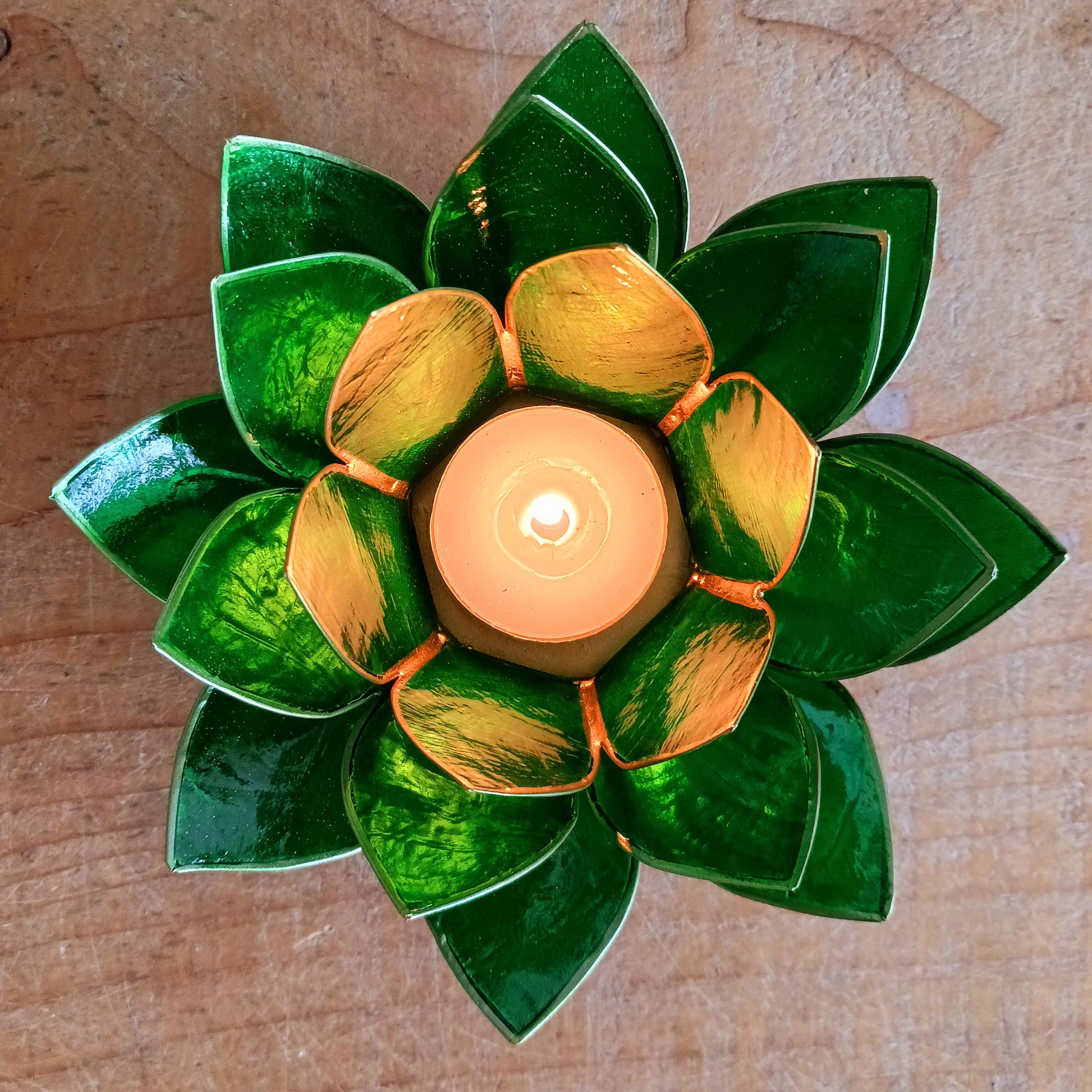 Illuminate your space with the peaceful elegance of our Capiz Shell Lotus Flower Candle Holder. Symbolizing enlightenment and serenity, this stunning handcrafted piece features delicate green petals edged in gold, forming the iconic lotus shape.