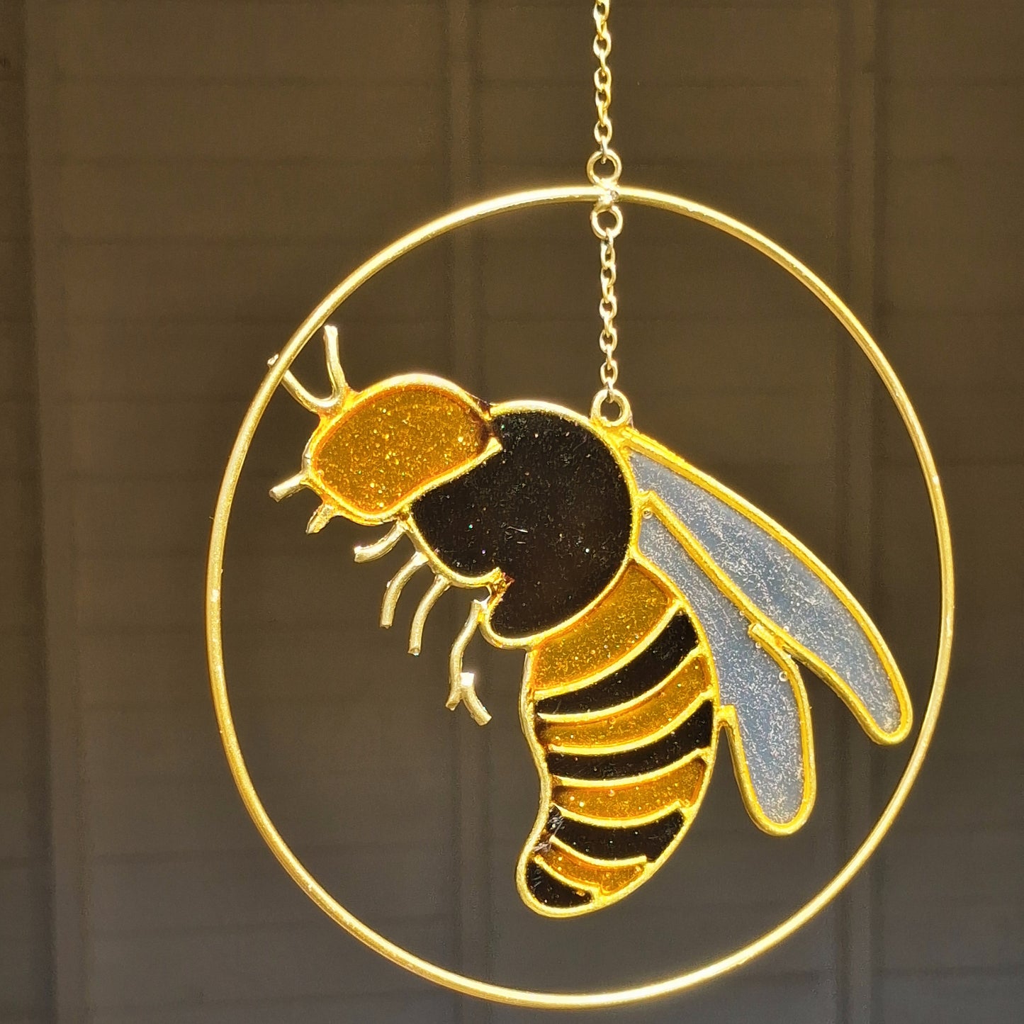 Add a touch of sunshine to the home with this summer bee suncatcher. This charming suncatcher features a beautifully detailed bee, star and crescent moon design made from metal and resin. Hang it in the window to catch the light and bring a cheerful, colourful glow to any room.