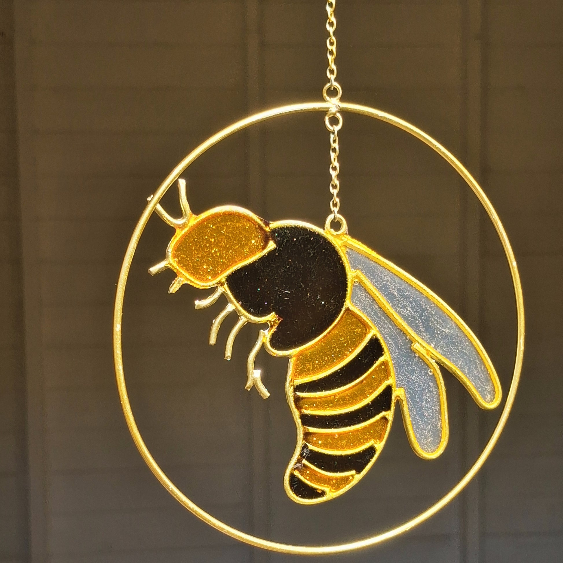 Add a touch of sunshine to the home with this summer bee suncatcher. This charming suncatcher features a beautifully detailed bee, star and crescent moon design made from metal and resin. Hang it in the window to catch the light and bring a cheerful, colourful glow to any room.