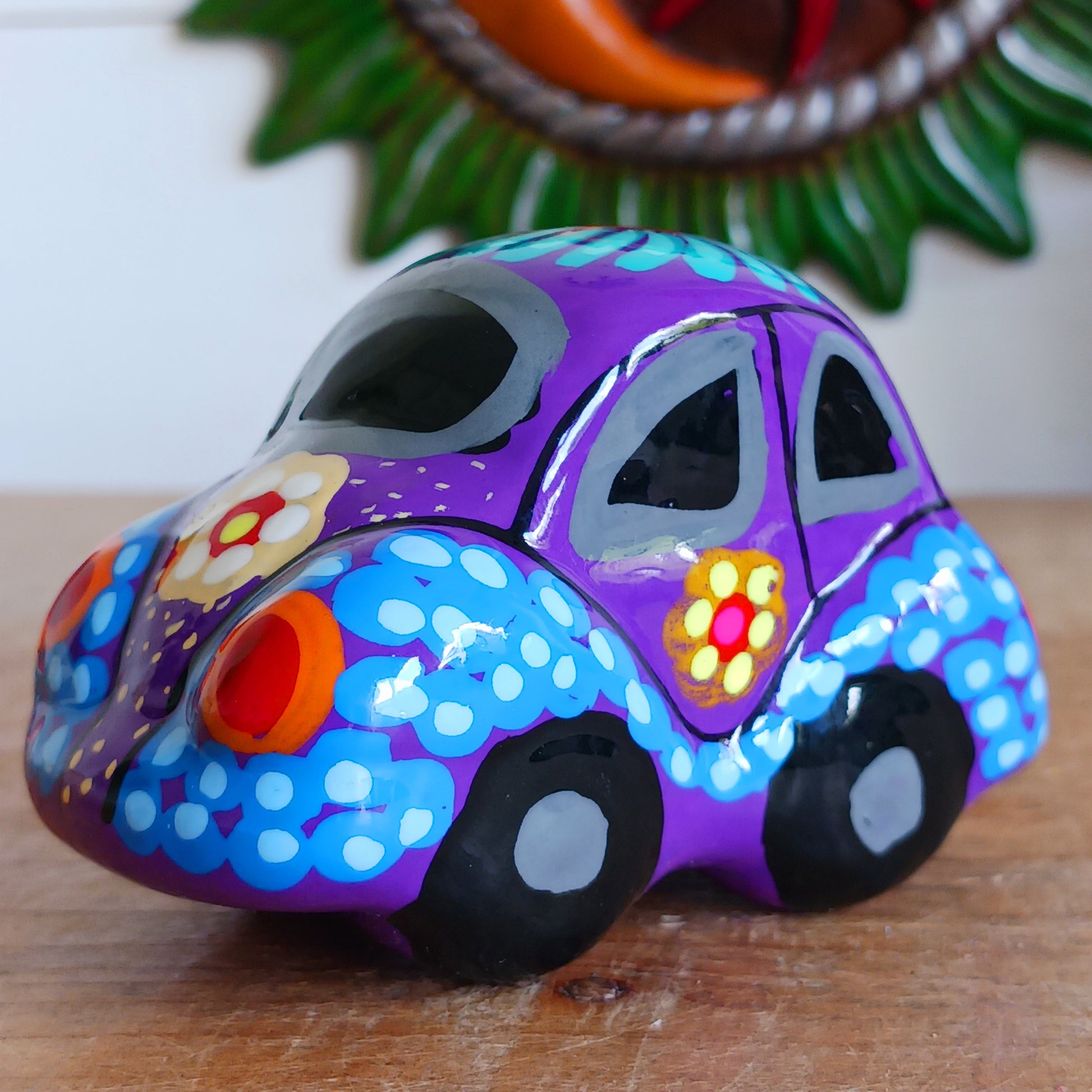 This fun little VW car ornament oozes retro vibes. With it's bold flower power design and vibrant colours it will brighten up any sideboard. This type of car, affectionately known as a 'bochito', are very popular in Mexico due to their reliability when driving about steep roads. Incidentally, the Mexican town of Puebla was home to the last Beetle production factory which only closed in 2003.