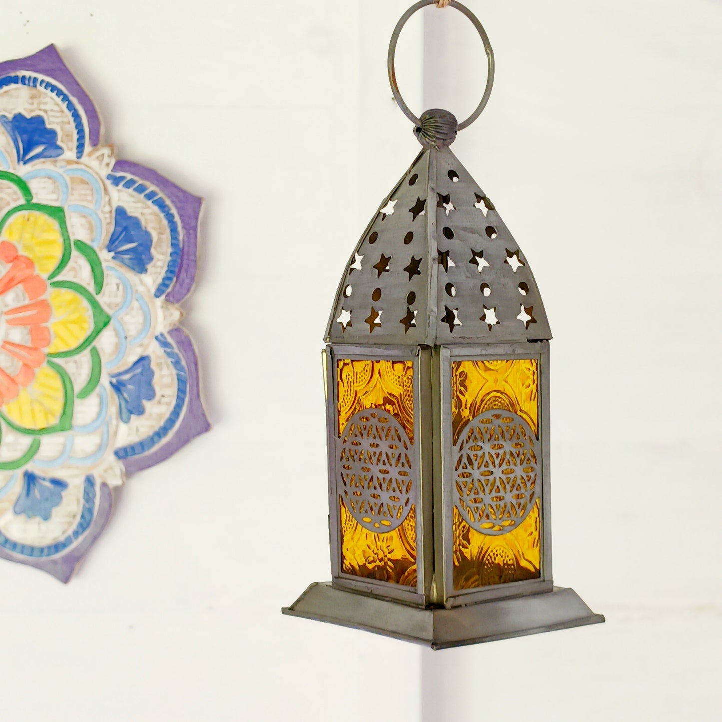 Bring warmth, colour and spiritual harmony to your home with this beautiful Tree of Life Glass Lantern. Designed with vibrant coloured glass panels and a decorative metal cut-out canopy, this lantern creates a calming glow that enhances meditation spaces, yoga rooms and home décor.