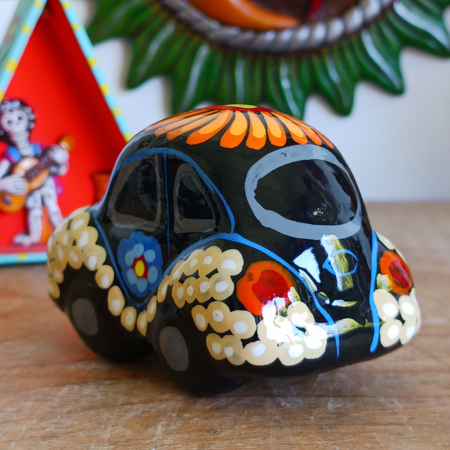 This fun little VW car ornament oozes retro vibes.  With it's bold flower power design and vibrant colours it will brighten up any sideboard.  This type of car, affectionately known as a 'bochito', are very popular in Mexico due to their reliability when driving about steep roads. Incidentally, the Mexican town of Puebla was home to the last Beetle production factory which only closed in 2003.